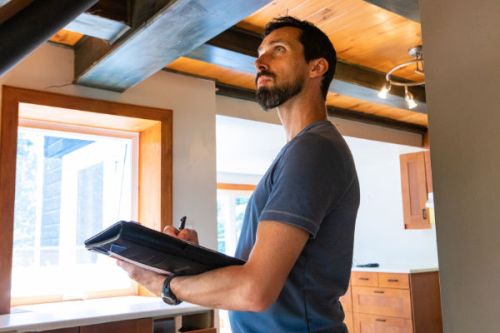 Homeowner inspecting home interior for maintenance issues